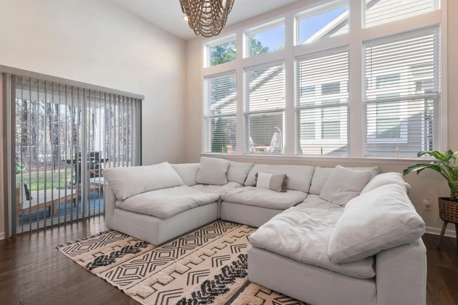 Bright living room with a white sectional, hardwood floors and tall windows